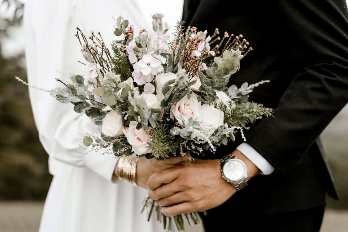 Couple holding white roses