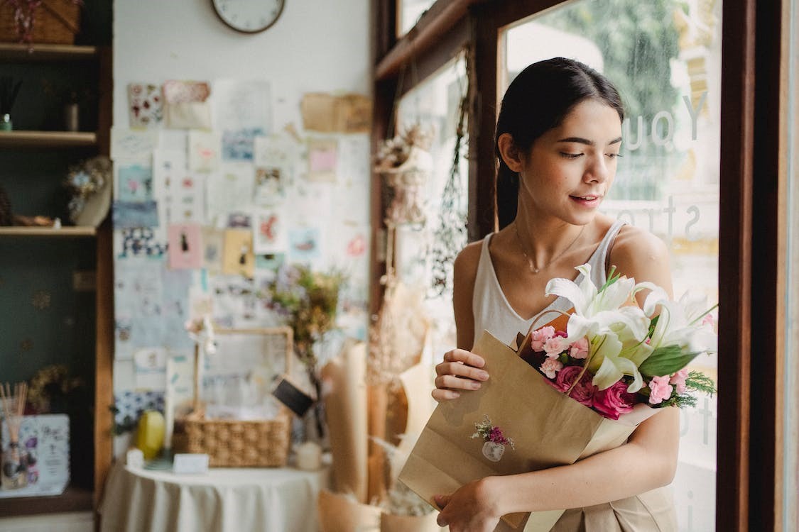 Person holding bouquet of lilies