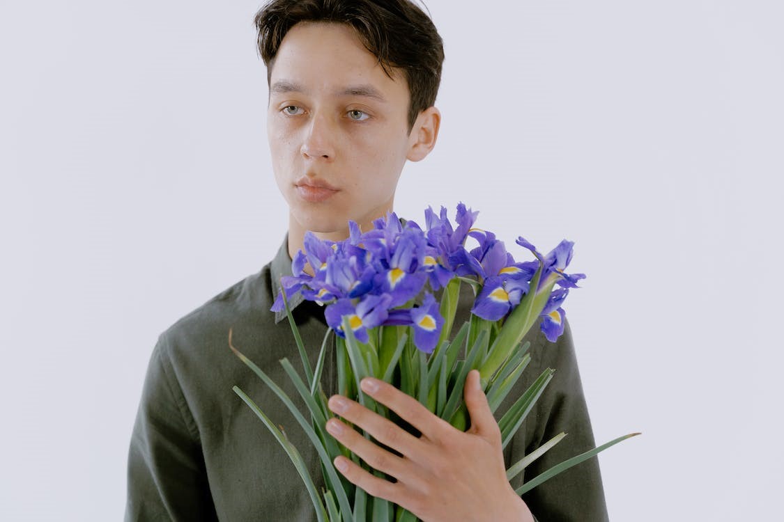person holding purple iris bouquet